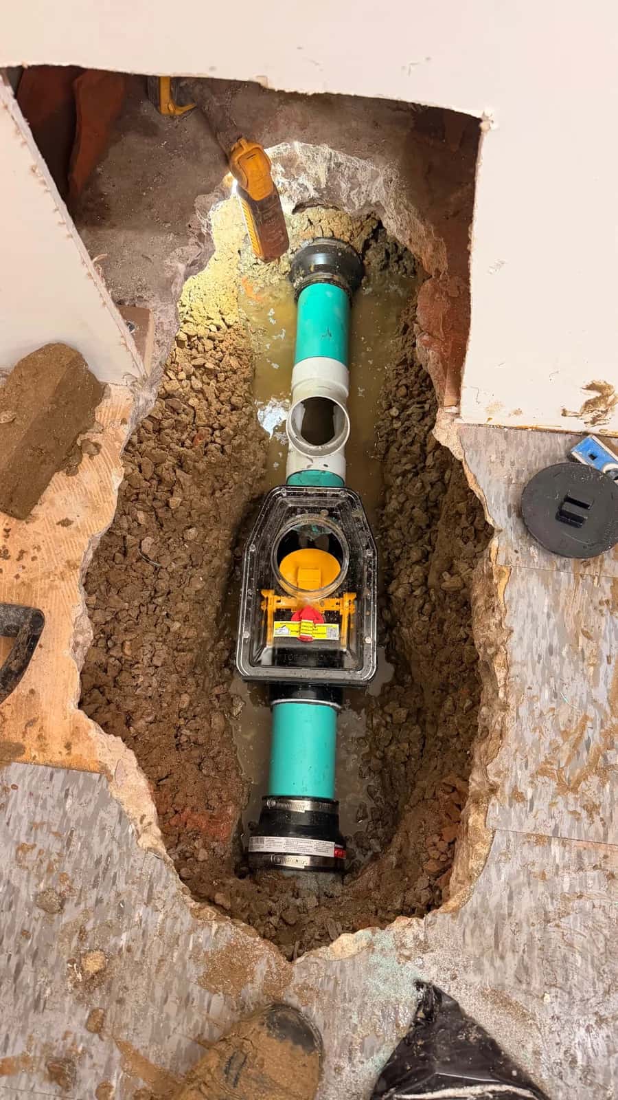 Backwater valve and new pipework in an opened basement floor