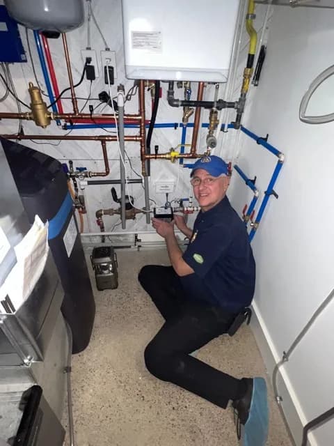 Michael installing an electronic wireless flood-protection system in a home's mechanical room.