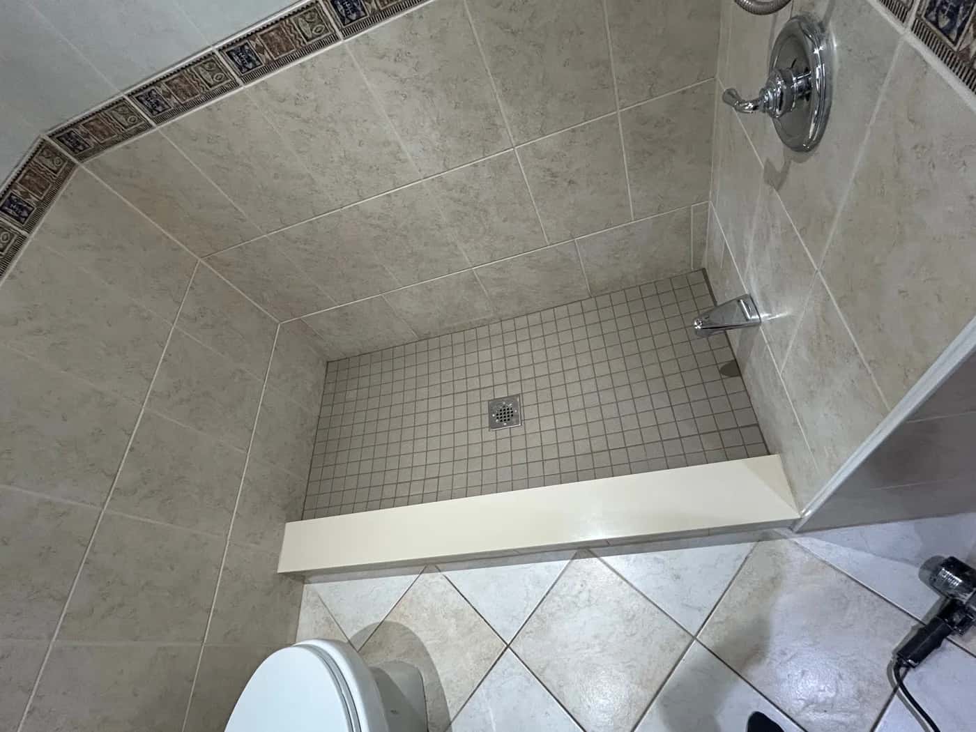 Tiled shower floor and walls in a Waterworks project photo