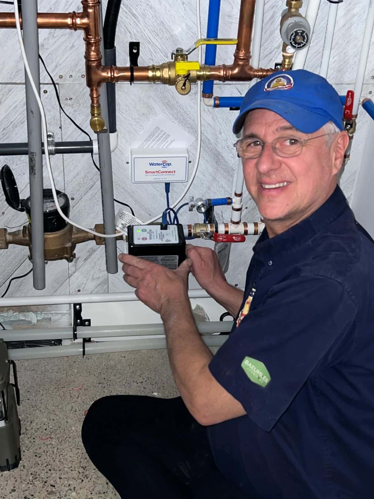 Waterworks plumber fitting a valve on copper water lines in a basement